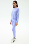 A woman faces slightly left, wearing the SPLITS59 Brooks Stripe Fleece Sweatshirt in Purple Haze/White with matching leggings, white socks, and sneakers against a plain light background.