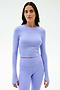 A woman poses against a plain background in the SPLITS59 Louise Rib Long Sleeve Crop - Purple Haze, paired with matching high-waisted leggings.