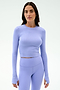 A woman poses against a plain background in the SPLITS59 Louise Rib Long Sleeve Crop - Purple Haze, paired with matching high-waisted leggings.