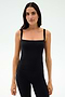 A woman faces forward in the SPLITS59 Monah Rigor Tank - Black and black leggings, set against a plain light background.