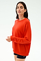 A woman in the SPLITS59 Andie Oversized Fleece Sweatshirt in Lotus Red and black shorts, made in Los Angeles, stands against a light background, facing the camera.