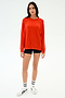 A person stands facing forward in the SPLITS59 Andie Oversized Fleece Sweatshirt in Lotus Red, black shorts, white socks with black stripes, and white sneakers against a plain white background. Made in Los Angeles for all-day comfort.
