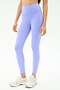 A woman wears SPLITS59 Sprint High Waist Rigor 7/8 leggings in Purple Haze with white sneakers, standing against a plain light background.