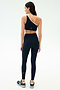 A woman faces away, wearing the SPLITS59 Amber Airweight High Waist 7/8 leggings in Indigo/White with a matching one-shoulder sports bra—perfect for hot yoga—paired with black sneakers against a plain white background.