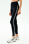 Wearing SPLITS59 Amber Airweight High Waist 7/8 leggings in Black/White with side stripes and white sneakers—ideal for hot yoga or casual wear against a plain backdrop.