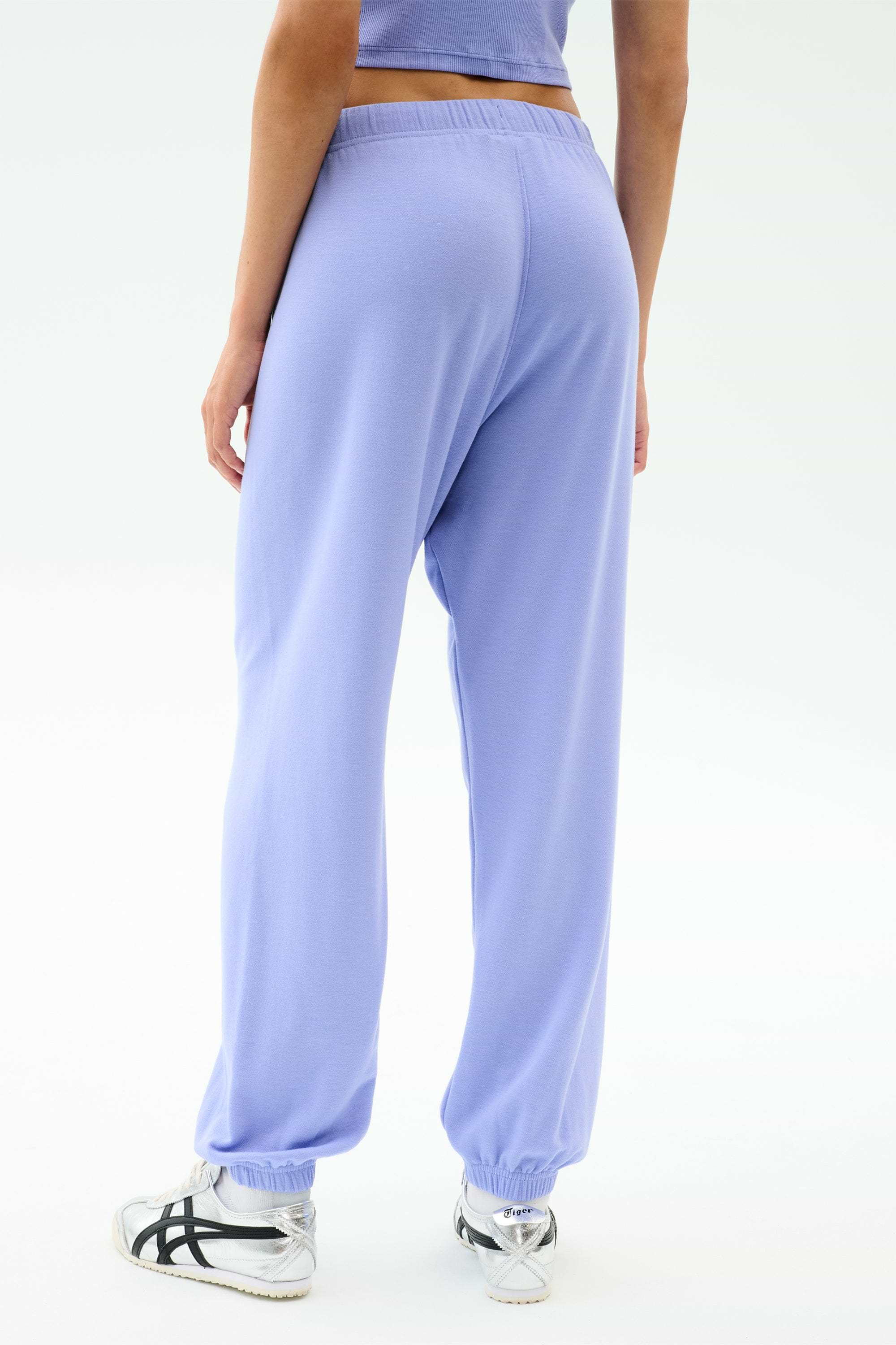 Shown from the back against a plain background, a person wears the SPLITS59 Andie Oversized Fleece Sweatpant in Purple Haze—an ideal, stylish choice for warm weather workouts.