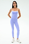 A person faces forward in SPLITS59 Clare High Waist Rigor 7/8 leggings in Purple Haze/White, paired with white sneakers, ready for the gym against a plain light background.