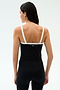 A woman wears the SPLITS59 Monah Rigor Tank in Black/White with black leggings, standing against a white background—an ideal look for gym workouts.
