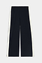 The SPLITS59 Jordan Nylon Twill Tearaway pants in Black/Creme are wide-leg pants crafted from a nylon-spandex blend, featuring white snap button panels running down the sides, and are displayed flat against a white background.