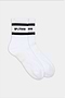 A pair of SPLITS59 Logo Stripe Ankle Socks With Grip in white, featuring black stripes and "SPLITS59" text near the cuffs, displayed on a plain background.
