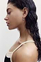 Profile view of a person wearing The Melrose Set by SPLITS59, featuring wet hair, a cream-colored top, and gold earrings.