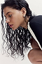 A person with wet hair wears a black and white The Soho Set athletic top while leaning forward.