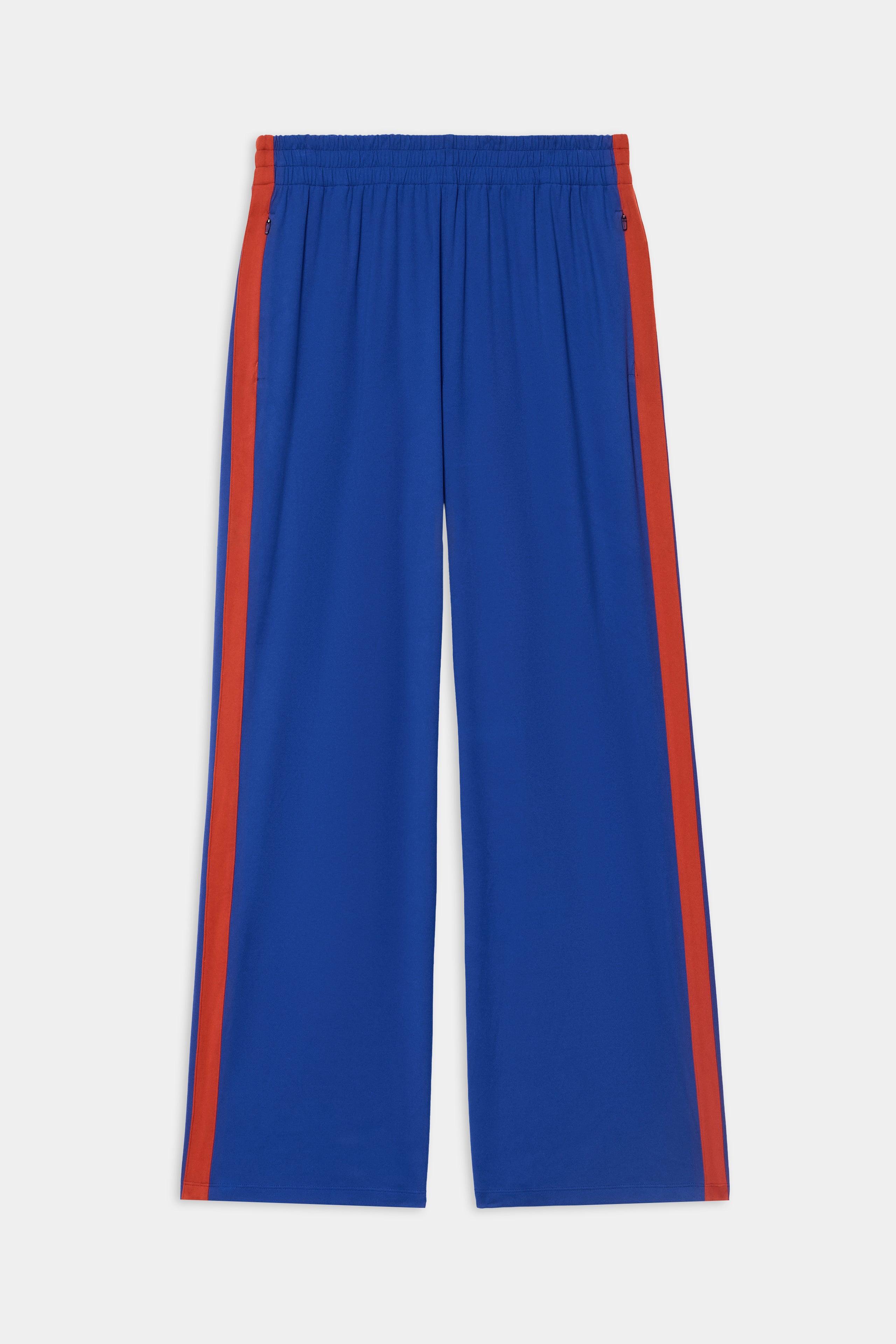 The SPLITS59 Maxie Rigor Track Pant - Cobalt/Terracotta features stretchy wide legs, elastic waistband, and terracotta red stripes, shown flat on a white background.