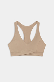 The SPLITS59 Mia Rigor Bra in Latte, a beige racerback sports bra crafted from a soft nylon-spandex blend, is laid flat on a white background.