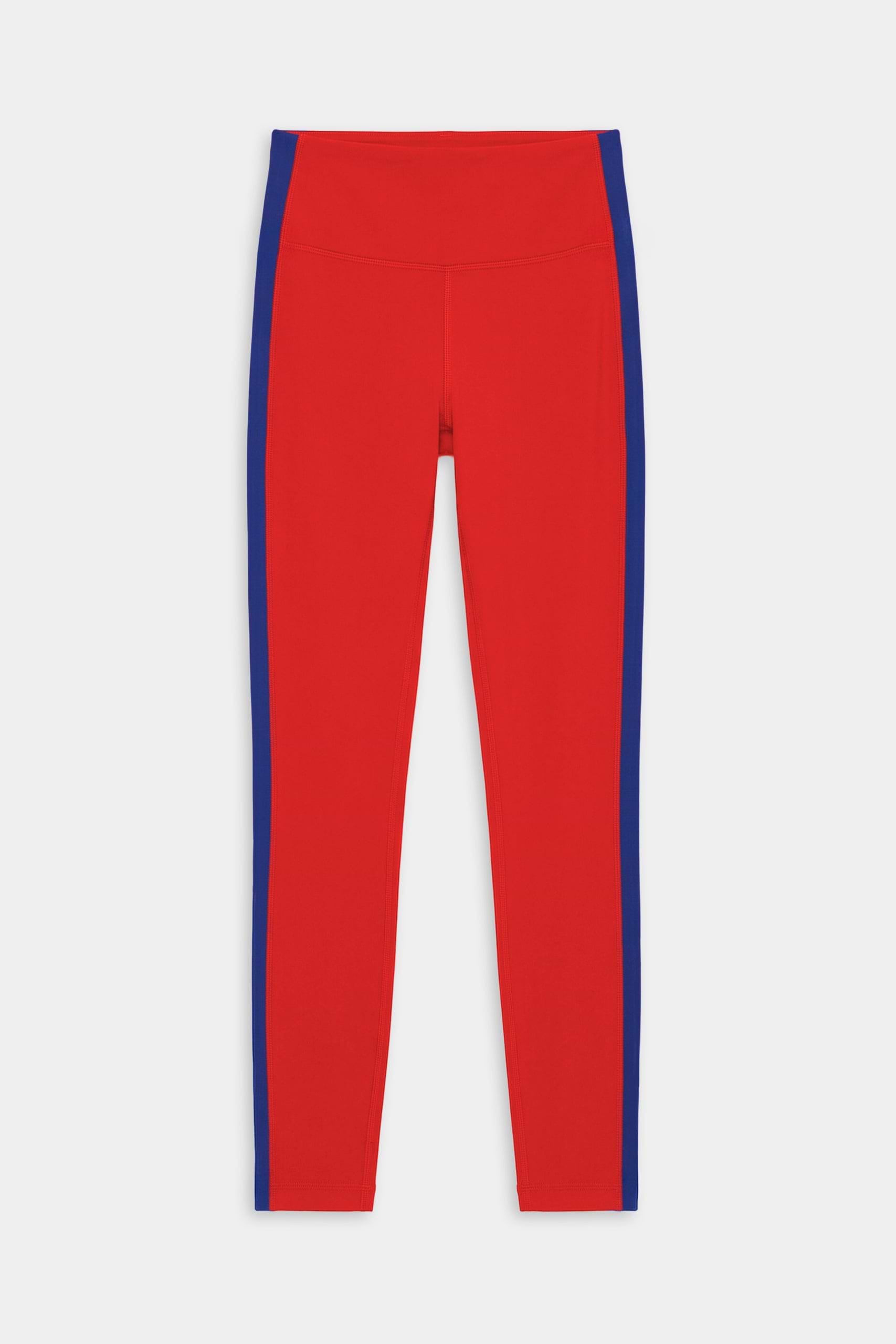 The SPLITS59 Clare High Waist Rigor 7/8 leggings in Lotus Red/Cobalt feature blue side stripes, performance Rigor fabric, and a high waist—perfect for gym workouts and shown laid flat on a white background.