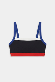 The SPLITS59 Monah Rigor Bra - Black/Cobalt features a color-blocked design with blue straps, a white upper band, black body, and red lower band—ideal for workouts. Shown on a white background.