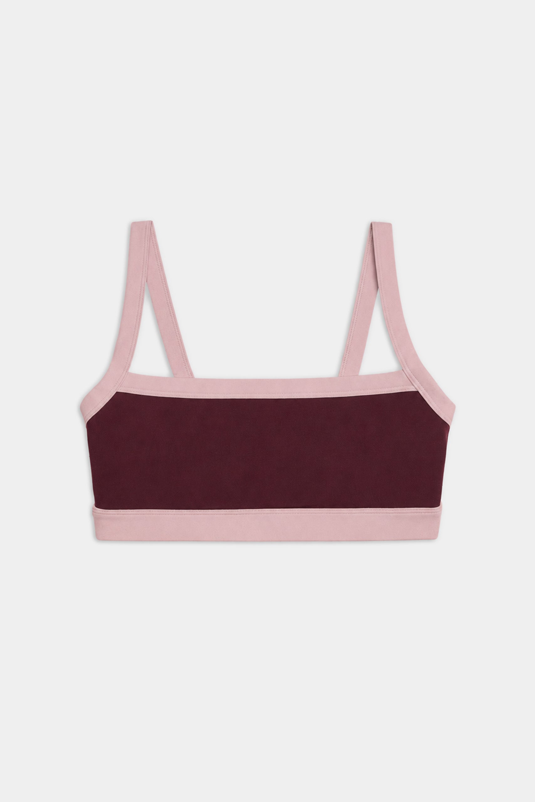The SPLITS59 Monah Rigor Bra in Dark Cherry/Blush features a color-blocked design with a dark maroon front panel and light pink straps, trim, and band, shown against a plain white background.
