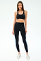 A woman faces forward wearing the SPLITS59 Ella Airweight Bra in Black/Classic Blue, paired with black leggings featuring blue side stripes and white sneakers against a plain white background.
