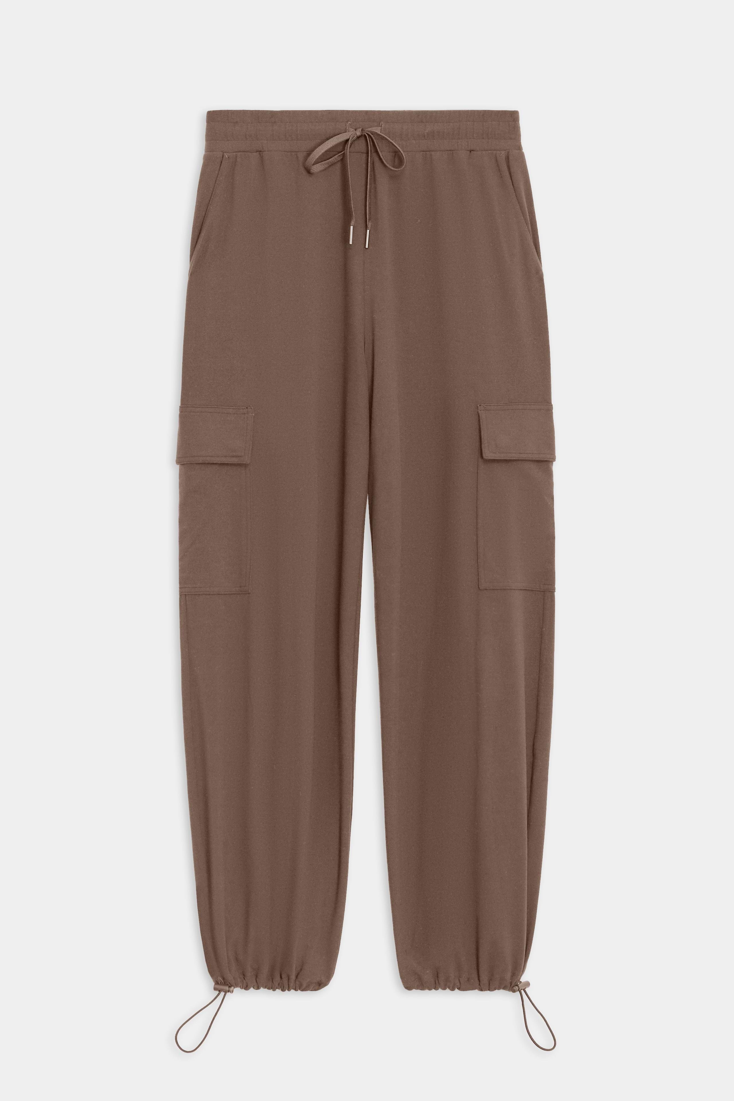 The SPLITS59 Nico Airweight Cargo Pant in Lentil offers lightweight comfort with an elastic waistband, drawstring tie, side pockets, thigh flap pockets, and adjustable ankle drawcords—perfect for workouts or casual wear. Shown flat on a white background.