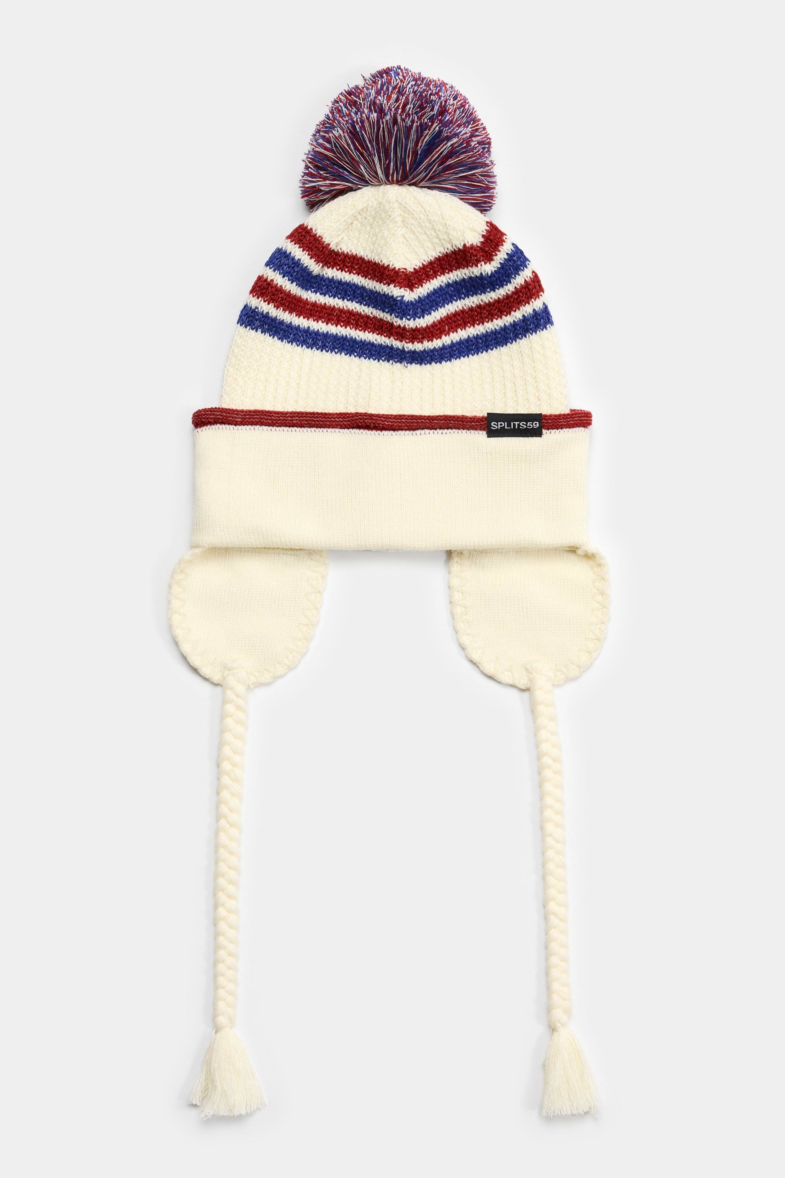 The SPLITS59 Pom Pom Beanie - Creme/Terracotta features soft polyester knit, colorful stripes, a pom-pom top, ear flaps, and braided tassels with fringe.