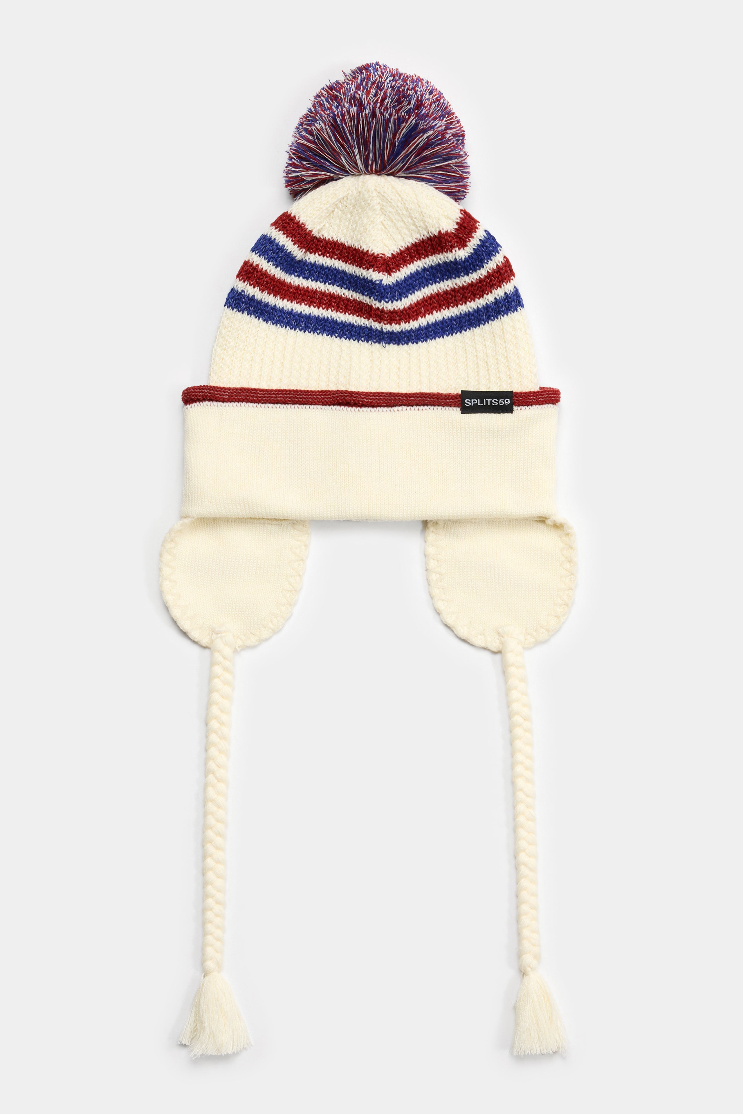 The SPLITS59 Pom Pom Beanie - Creme/Terracotta features soft polyester knit, colorful stripes, a pom-pom top, ear flaps, and braided tassels with fringe.