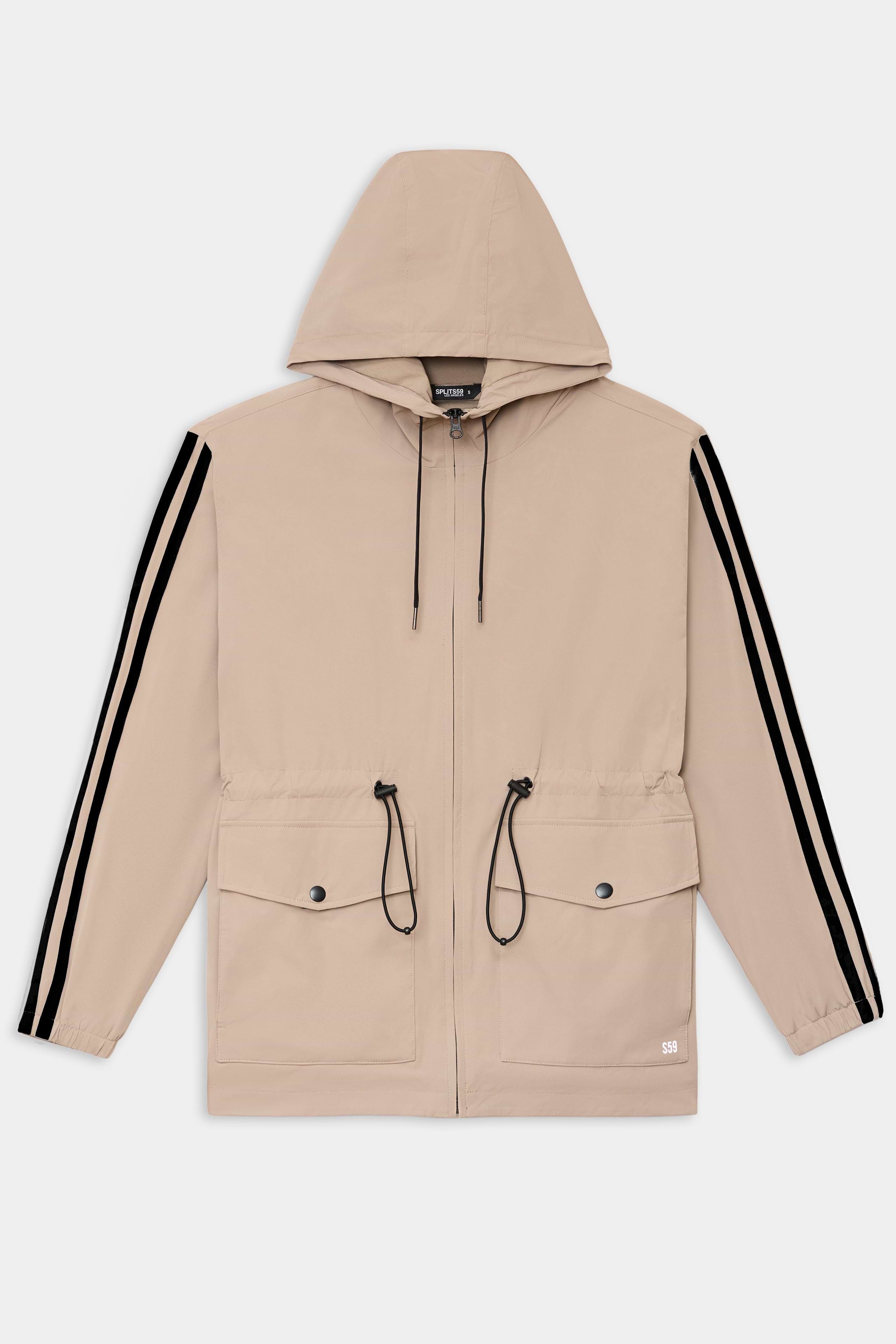 The SPLITS59 Reggie Water Repellent Jacket in Latte/Black features a lightweight design, black drawstrings, two front flap pockets, and black sleeve stripes—a versatile choice for any occasion.