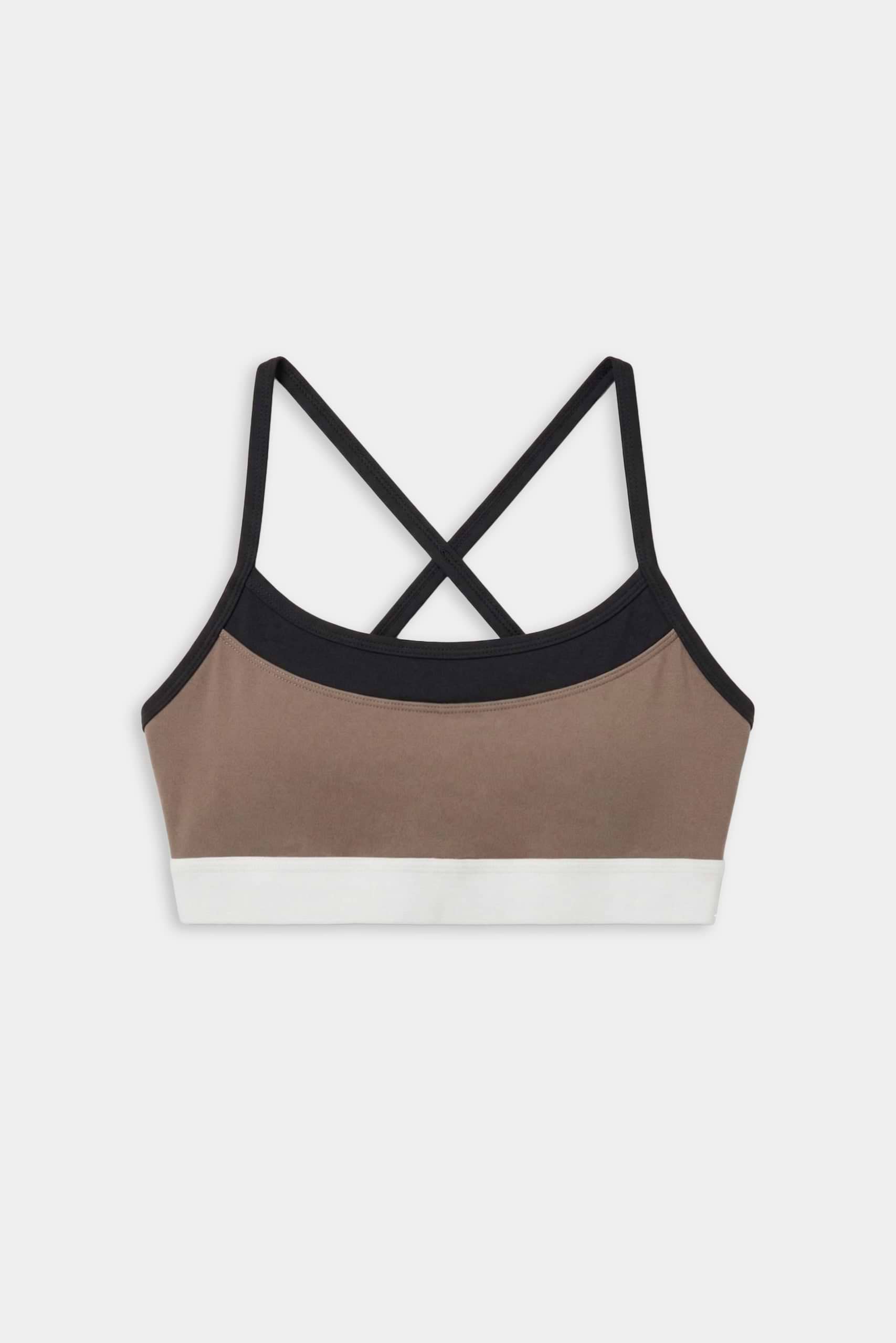 The SPLITS59 Scottie Airweight Bra in Lentil/Black is a colorblock sports bra with black straps, a tan front panel, black trim, and a white bottom band, made from spandex and nylon. Displayed on a white background.