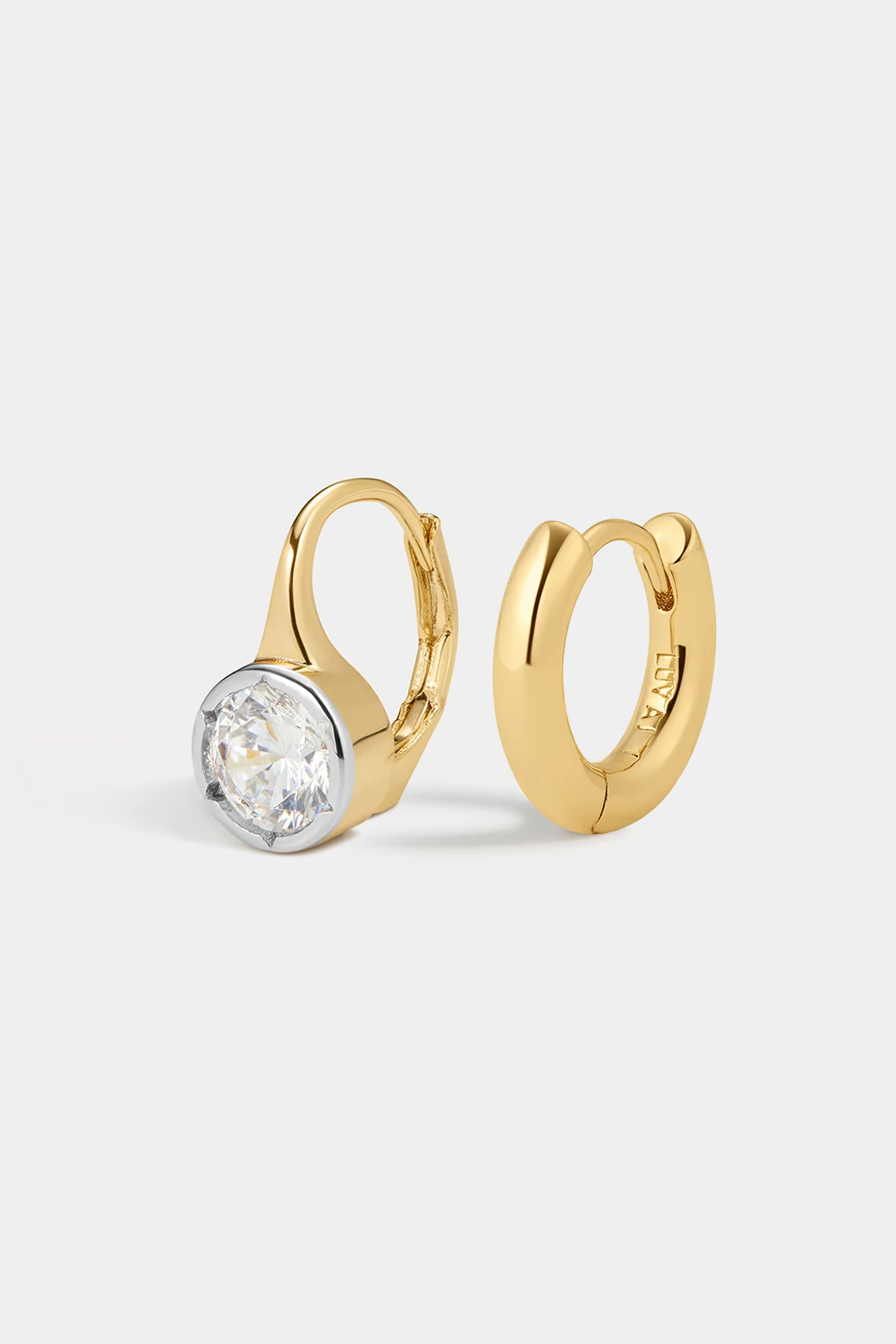The Melrose Set featuring a gold hoop earring with a single round-cut white stone in a bezel setting alongside a plain gold hoop earring.