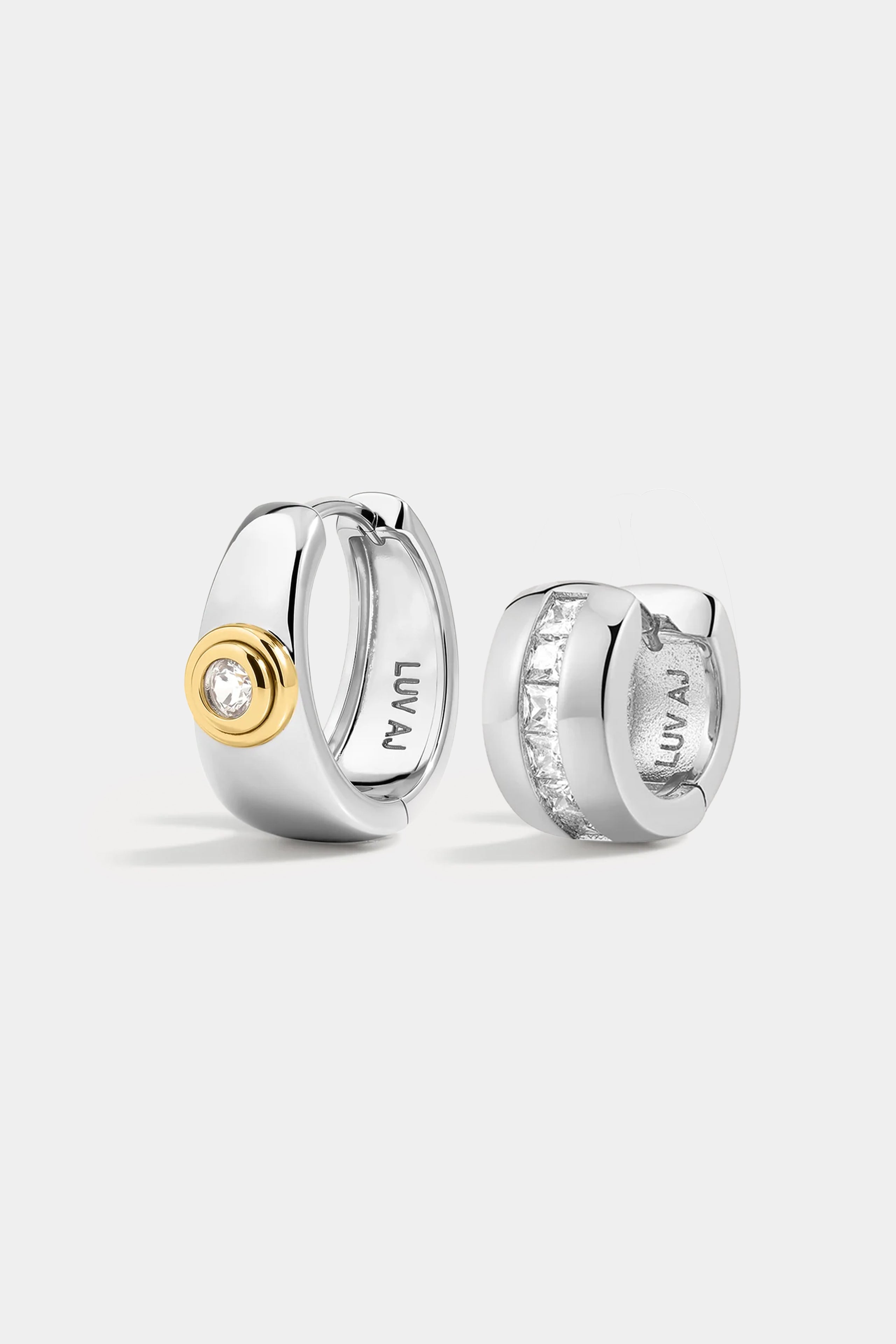 The Soho Set featuring two silver hoop earrings: one with a central gold-tone circle set with a round stone, and one with a row of channel-set square stones.