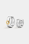 The Soho Set featuring two silver hoop earrings: one with a central gold-tone circle set with a round stone, and one with a row of channel-set square stones.