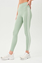 Side view of girl wearing light green leggings with two thin white stripes down the side with white shoes