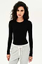 A woman wearing a SPLITS59 Loren Seamless L/S Tee in Black and grey sweatpants for yoga.