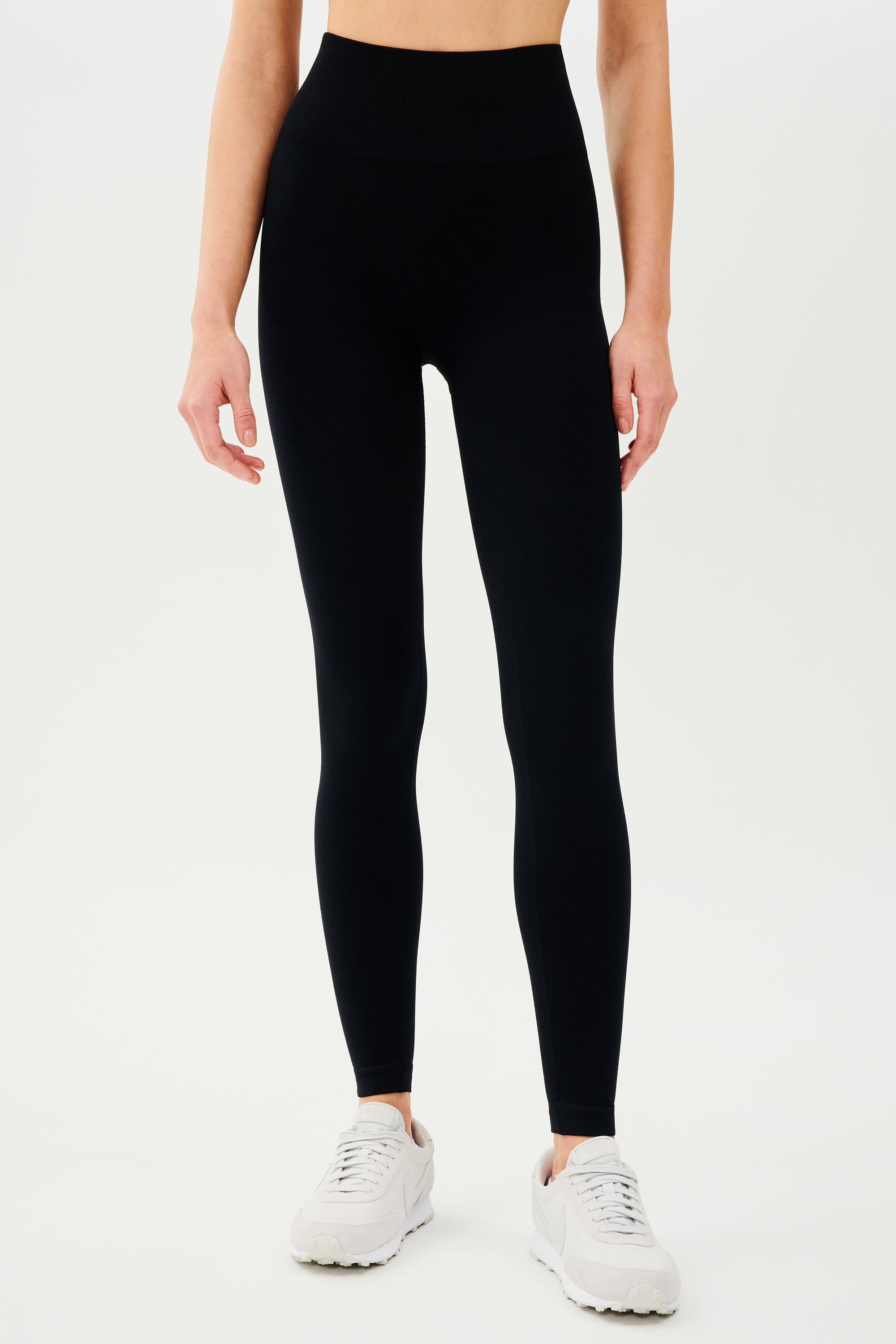 The back view of a woman wearing SPLITS59's Loren Seamless High Waist Full Length - Black leggings.