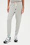 A woman wearing comfortable, SPLITS59 Kiki Rib 7/8 Sweatpant in Heather Grey and sneakers.
