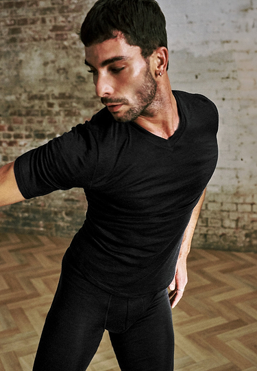 General view of a men model wearing HA black silk S/SLV Shirt V-Neck
