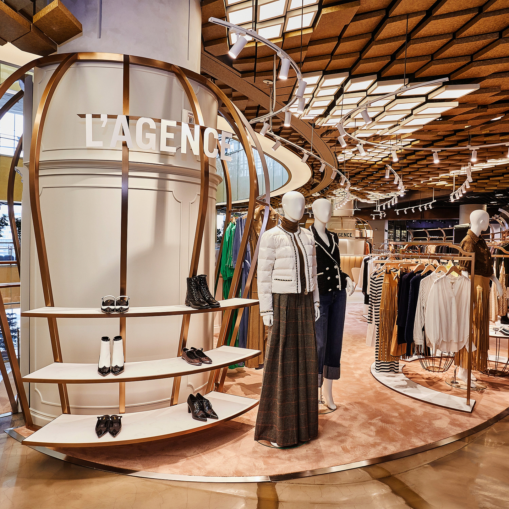 Interno di un negozio di moda con manichini e capi esposti, caratterizzato dal marchio «L'Agence».