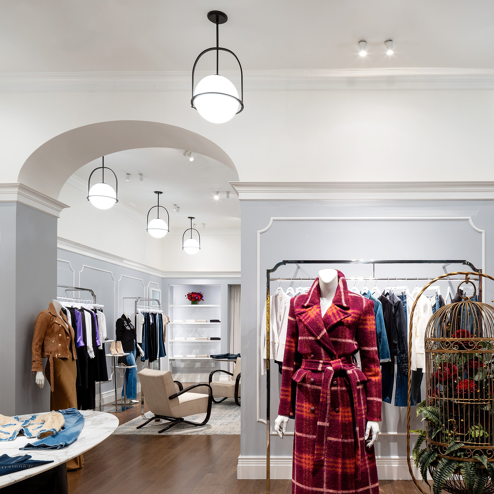 Interior of a stylish clothing store with a red plaid coat on a mannequin.