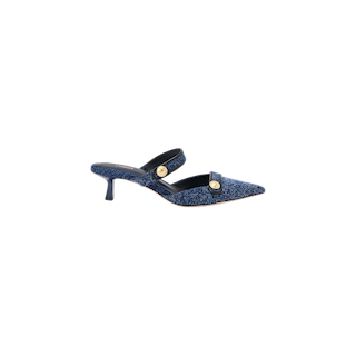 The Gilliane Denim Mule is shown on a white background, featuring a blue, pointed-toe design with two straps—each adorned with embossed dome buttons in round gold accents. This mule also includes a comfortable memory foam cushion for added support.