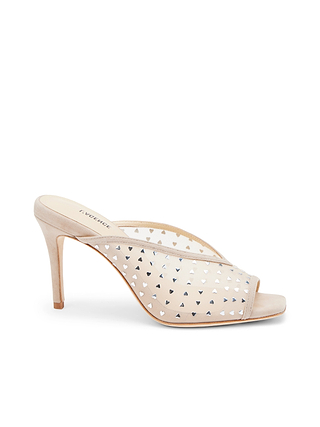 The Germain Open-Toe Mule is a beige suede stiletto with a transparent mesh upper embellished with small silver triangular studs, featuring an open toe and a slim, elegant silhouette.