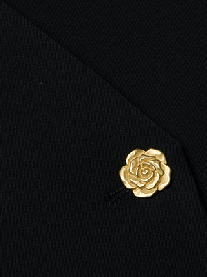Close-up of the L'AGENCE Romy Tie Neck Blazer's sleek black lapel, accented with a gold rose-shaped pin for an elegant finish.