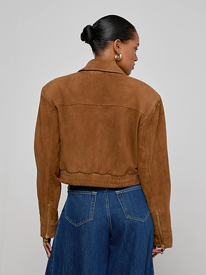 A person with dark hair in a bun wears the Micah Oversized Suede Jacket and high-waisted blue jeans, shown from the back against a plain light gray background.