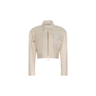 The Micah Oversized Leather Jacket features a cropped silhouette in light beige leather, with a gold zipper, two front flap pockets, long sleeves, and a shirt-style collar. The background is plain white.