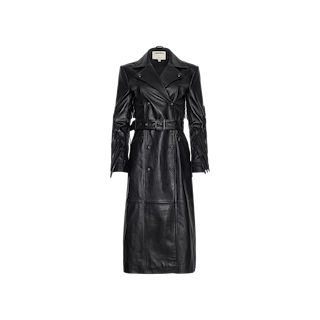 The Celina Fringed Leather Trench is a long black trench coat crafted from supple lambskin leather, featuring a double-breasted front, wide lapels, belted waist, and button details, displayed against a plain white background.