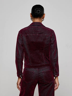 Model with hair in a bun wears the L'AGENCE Maven Flocked Jean Jacket, shown from the back with matching pants against a plain light gray background.