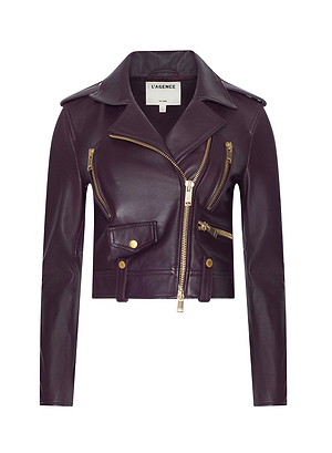 The Blakely Leather Biker Jacket is a cropped, deep burgundy leather jacket with gold zippers and an asymmetrical front zip—Channeling historical romance, it’s perfect for Fall 2026 or a New York Fashion Week statement. The label reads L’AGENCE.