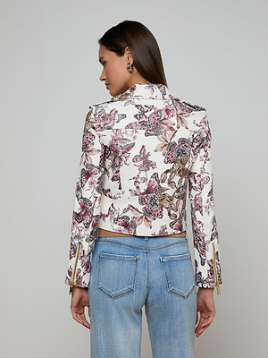 A woman facing away wears the Blakely Leather Biker Jacket in white lambskin with a pink and purple floral print, paired with light blue jeans against a plain light background.