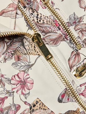 Close-up of the Blakely Leather Biker Jacket in white lambskin, featuring a floral and leopard print with pink flowers, leaves, gold zippers, and pulls—a bold choice for standout style.