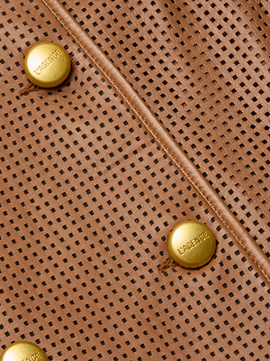 Close-up of tan perforated leather from the Baylee Leather Trench Coat, featuring diagonal stitching and three round gold buttons engraved “LASERVICE.” Small holes add texture to this sophisticated outerwear piece.