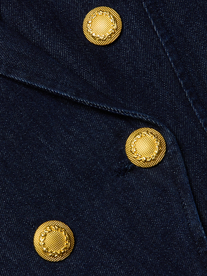 Close-up of the Emerson Blazer by L'AGENCE in navy denim, featuring three diagonally arranged gold textured buttons, detailed stitching, and fabric texture inspired by a double-breasted design.