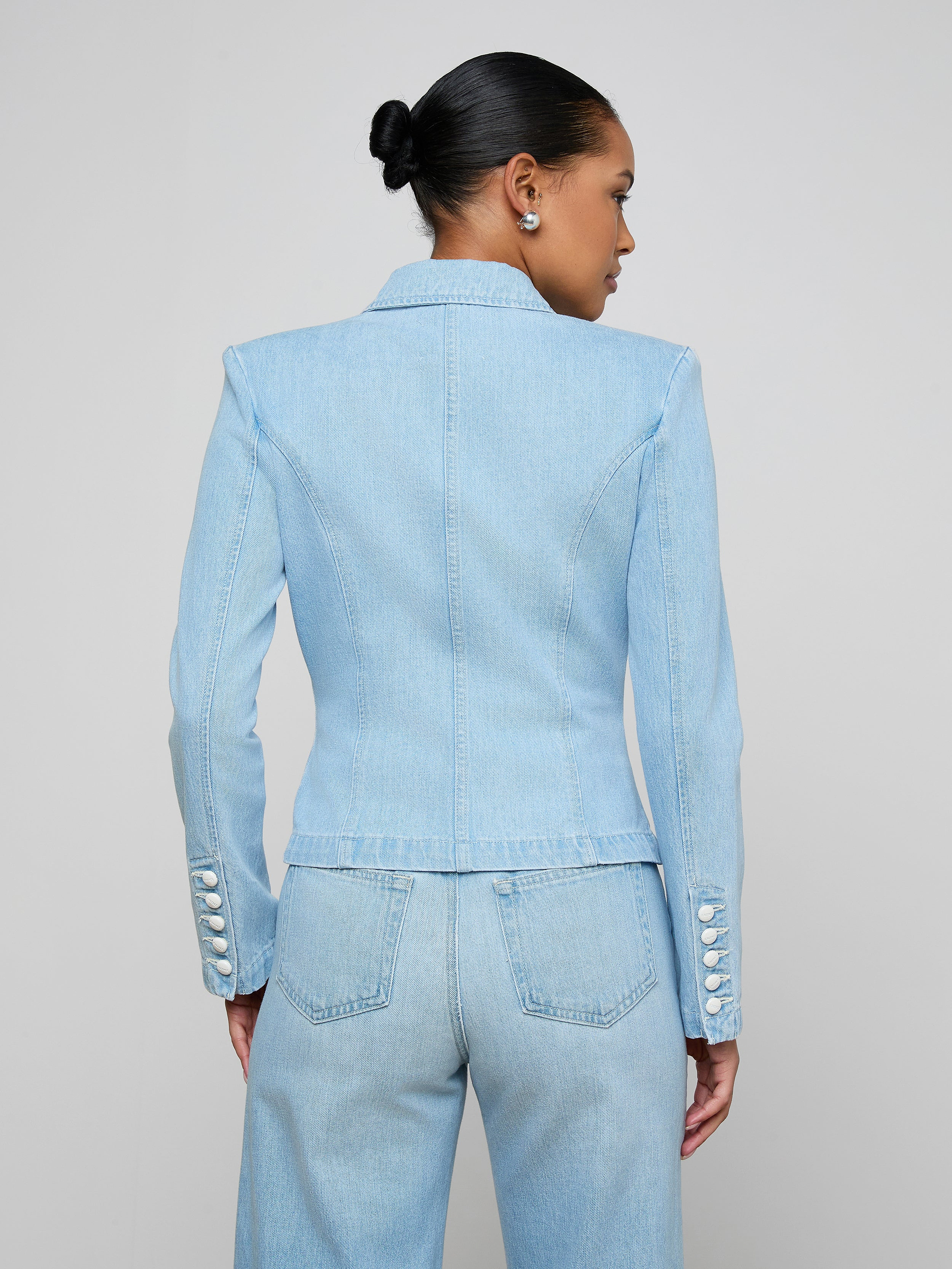 A person with dark hair in a bun is wearing the Emerson Structured Blazer, shown from the back against a plain light background.